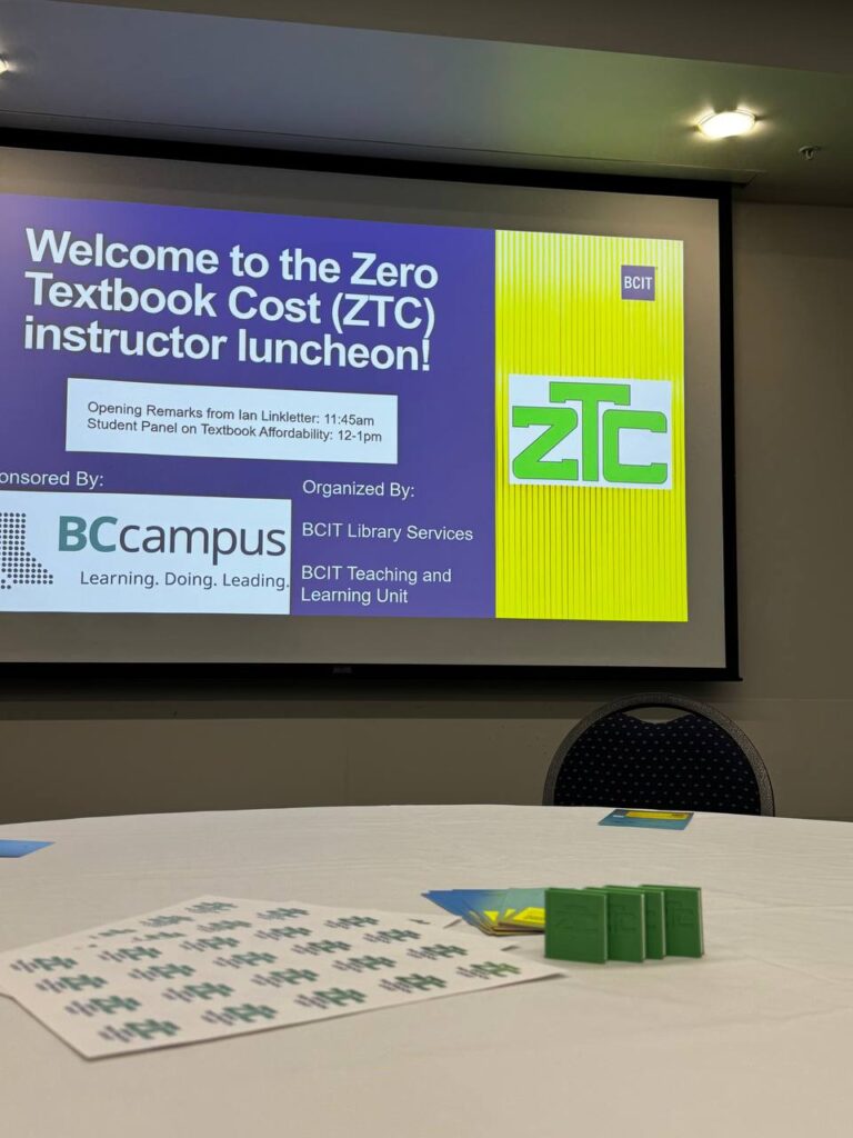 A table at the front featuring ZTC merchandise and a screen displaying the text: 'Welcome to the Zero Textbook Cost (ZTC) Instructor Luncheon.'